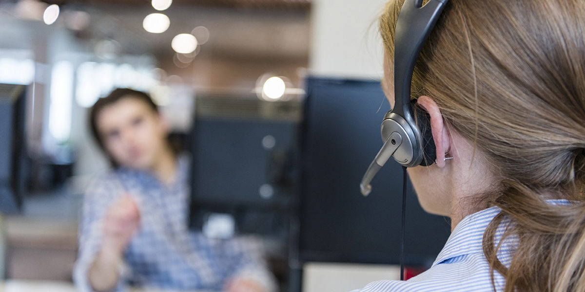 female customer support phone operator with headset  at workplace